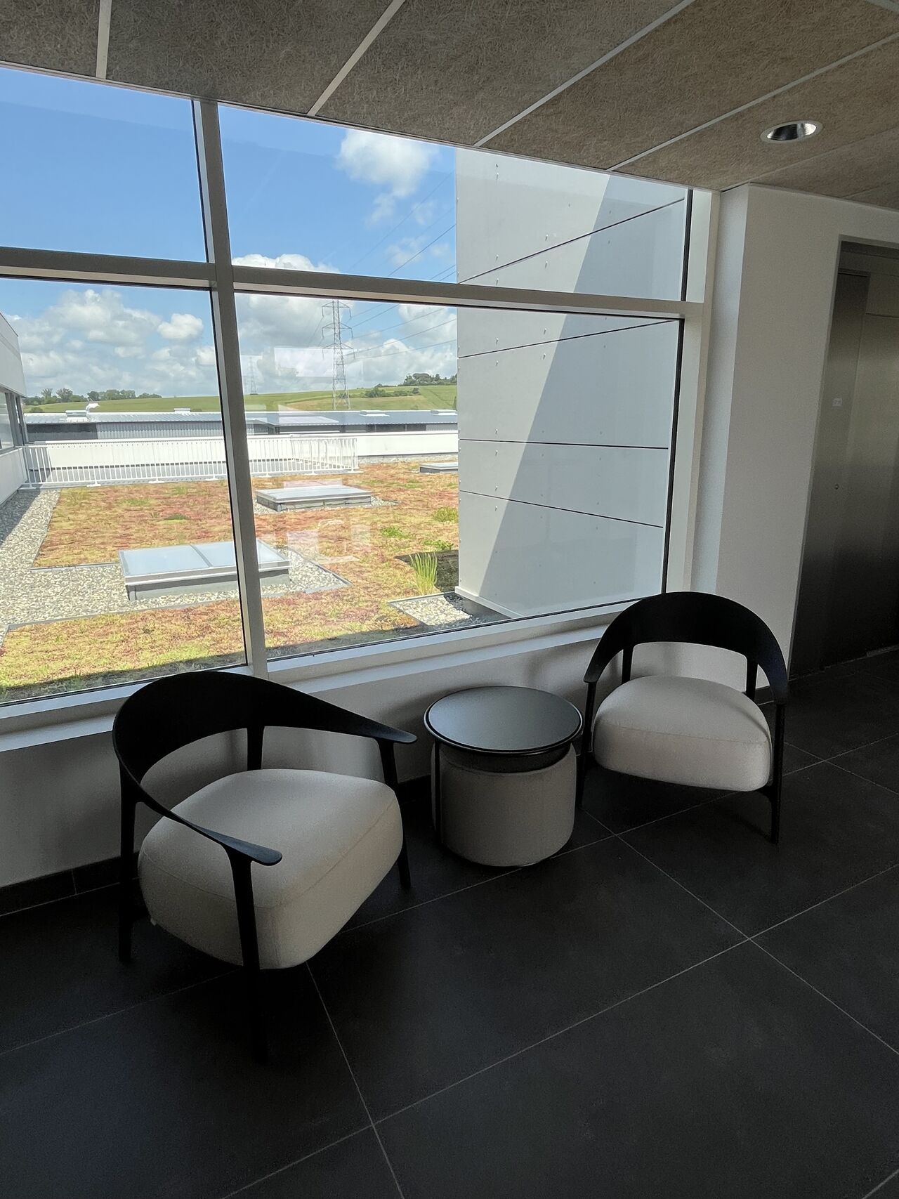 Espace détente aménagé par I Log You, fauteuils lounge devant baie vitrée