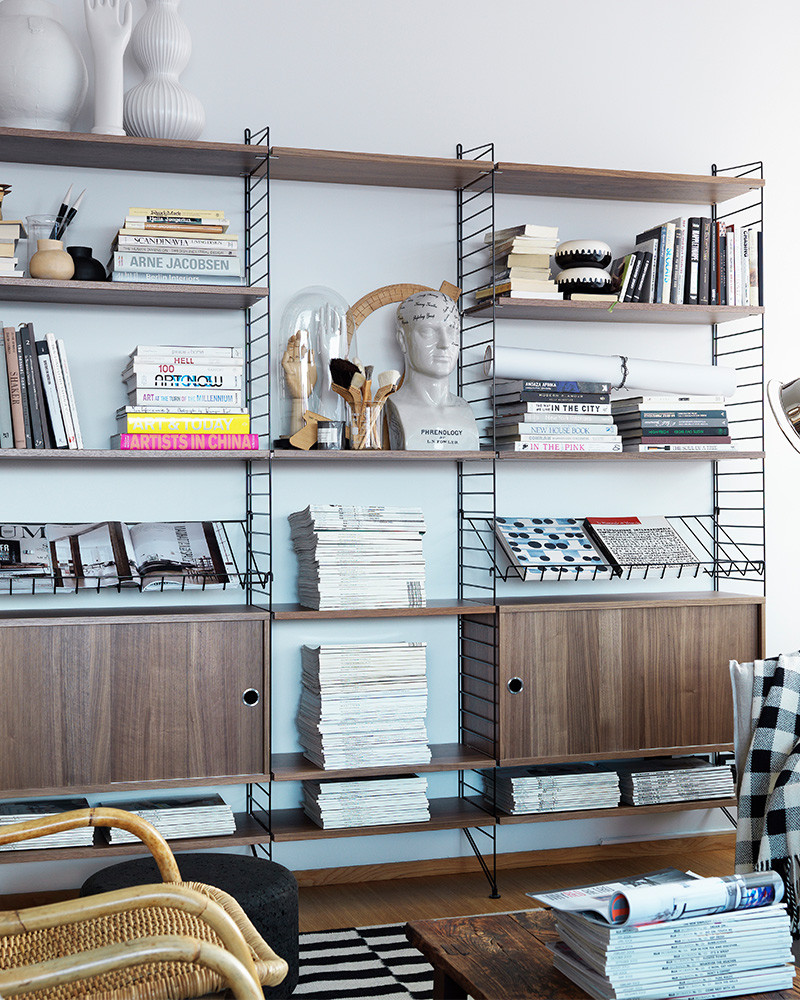Étagère String installée avec livres, magazines et objets déco