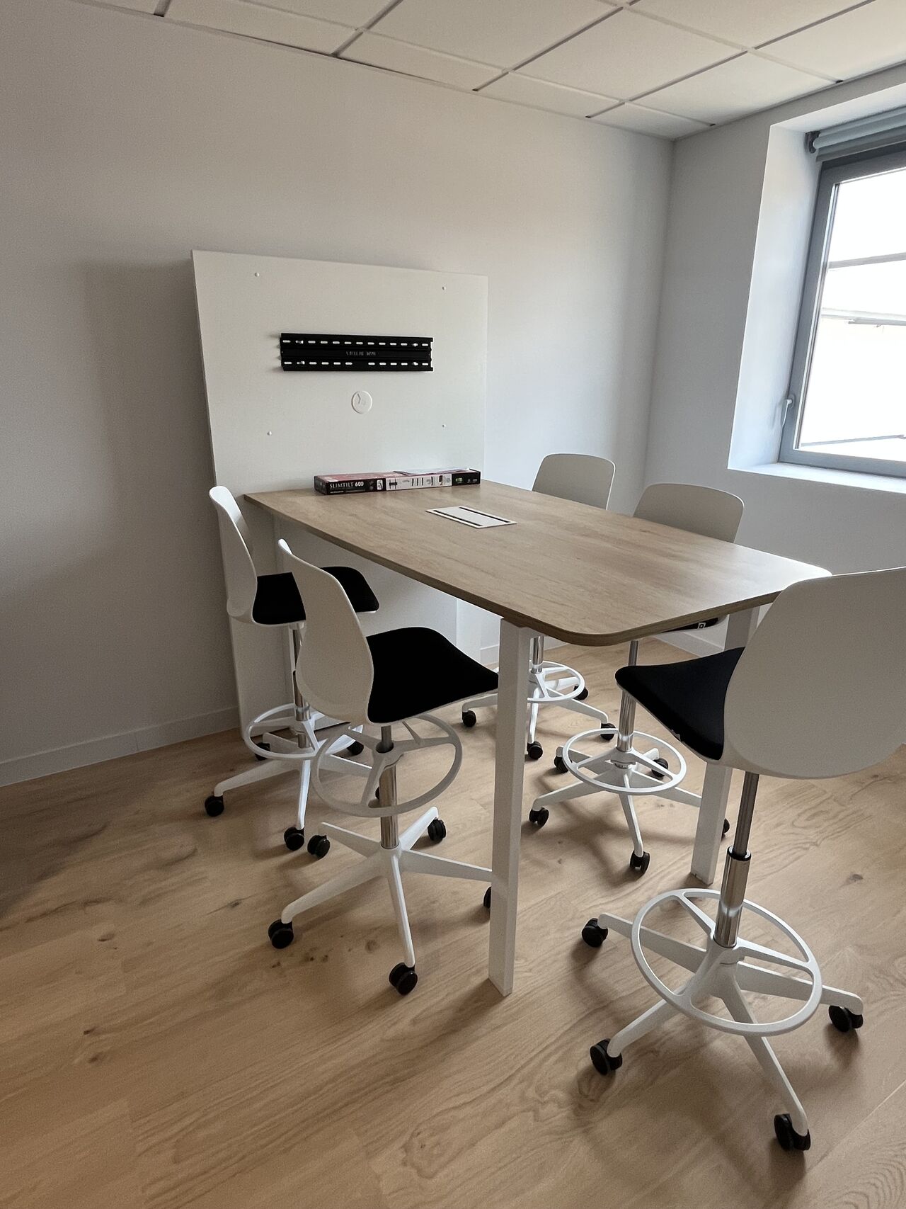 Coin réunion informel aménagé par I Log You avec table haute et tabourets