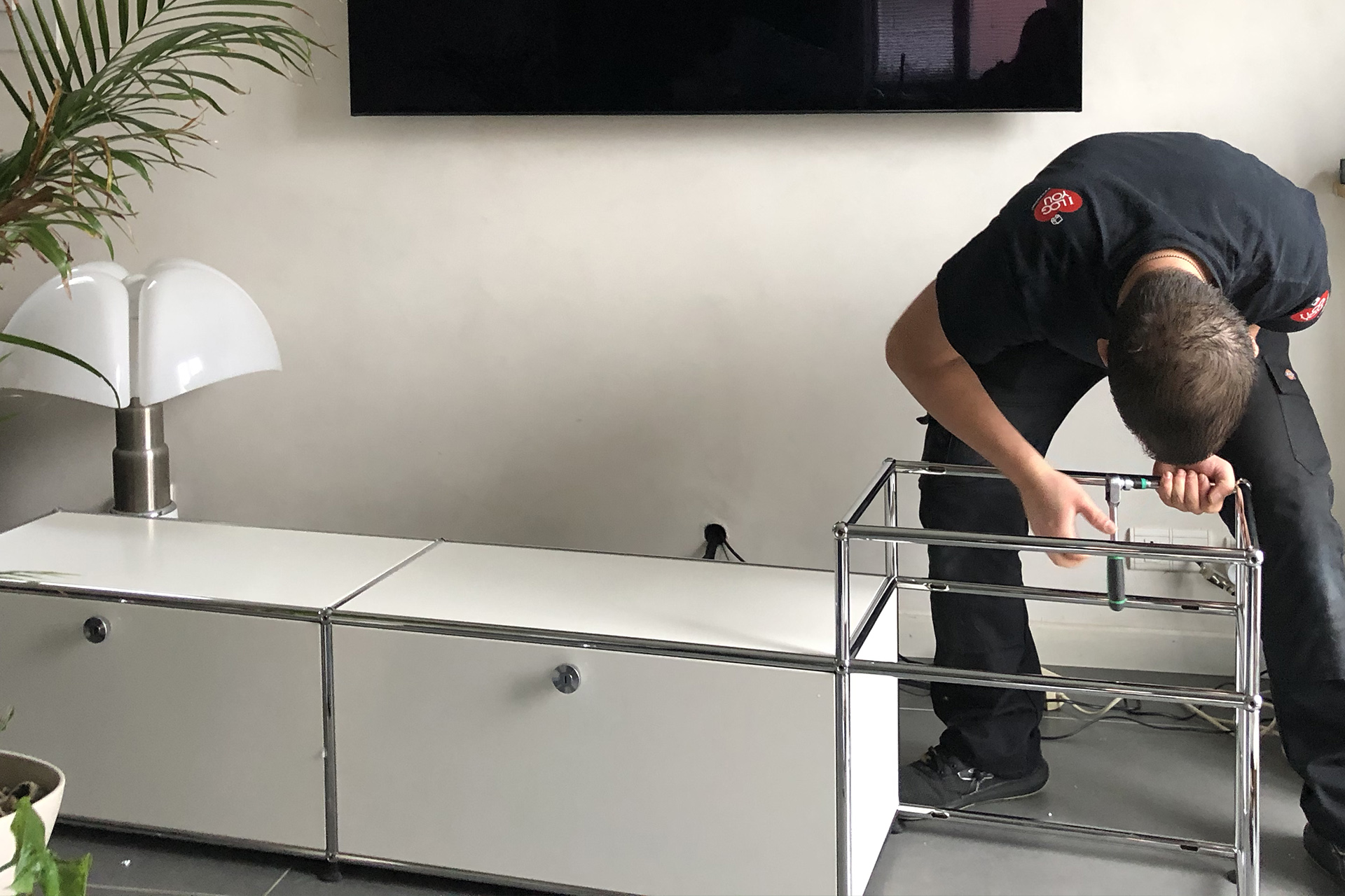 Technicien I Log You assemblant une structure USM Haller chez un client