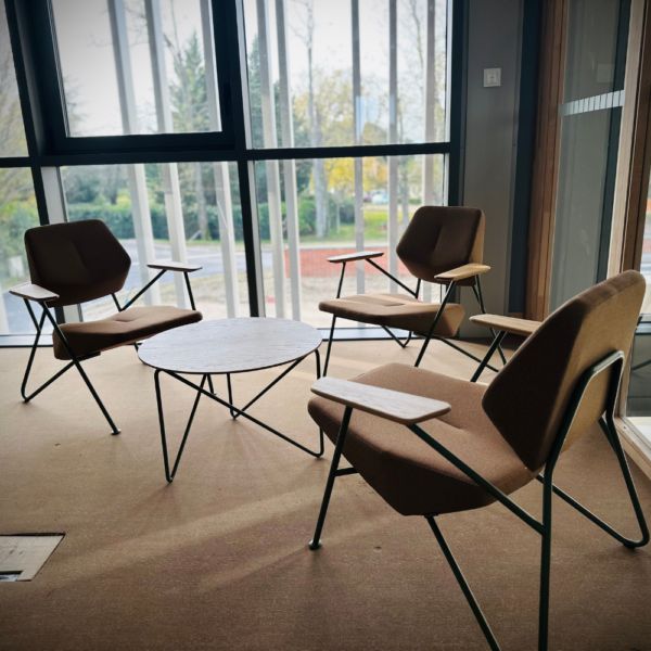 Espace lounge avec fauteuils design et table basse ronde