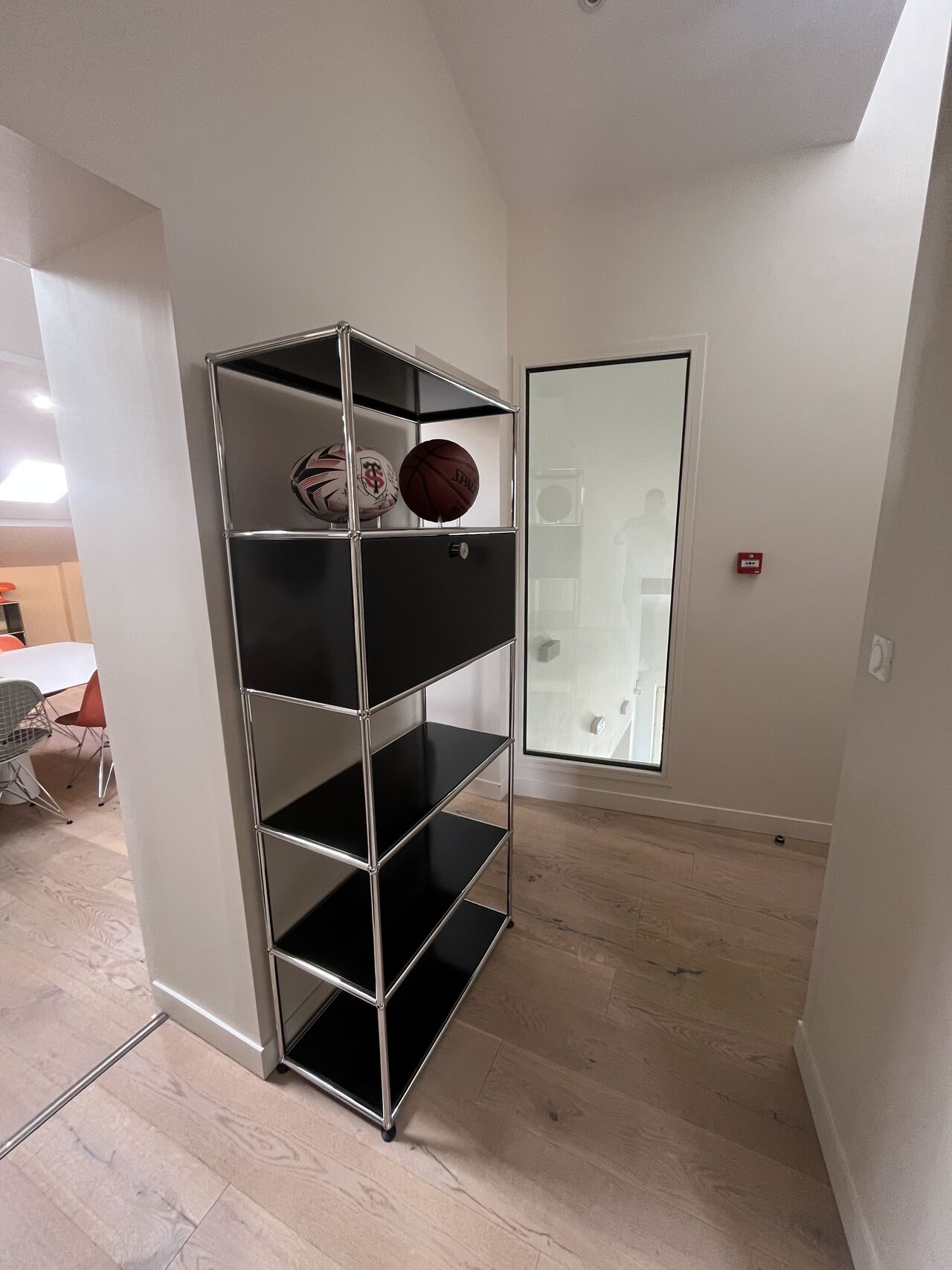 Étagère USM Haller noire haute installée dans un couloir mansardé
